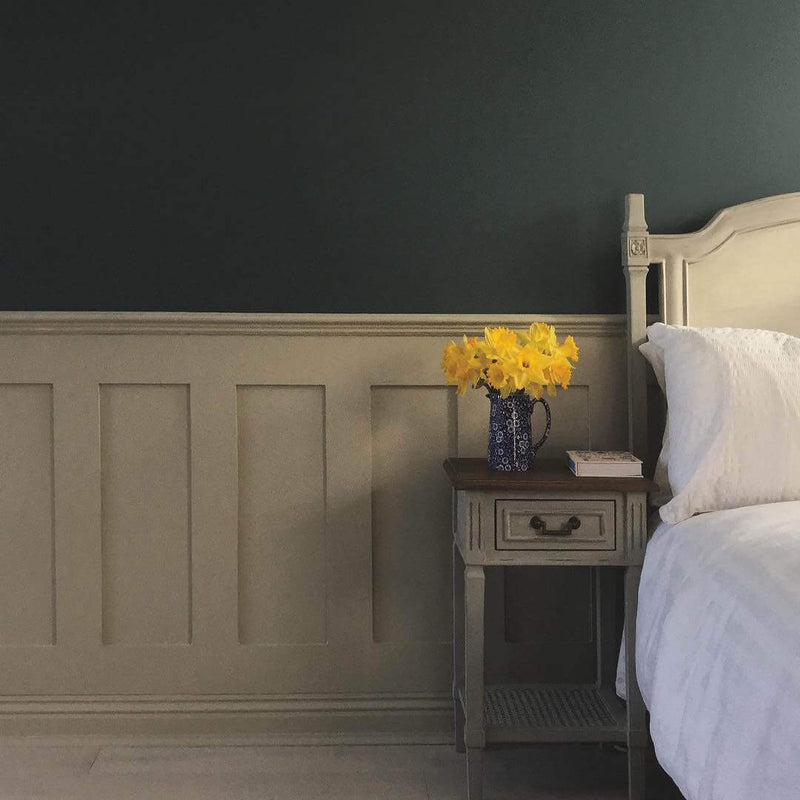 Bedroom with a nightstand featuring Edwardian MDF Wall Panelling and a vase of yellow flowers against a dark wall.
